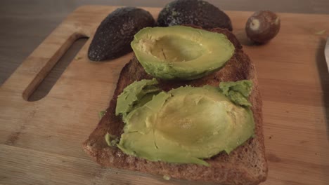 Avocado-On-Toast-Bread-On-Top-Of-Wooden-Board---high-angle,-close-up