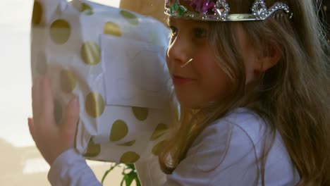 adorable girl shaking birthday gift at home 4k