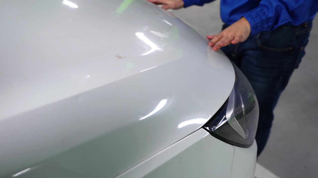 manos masculinas cerrando el tubo de limpieza de parabrisas lleno de un coche y bajando el capó