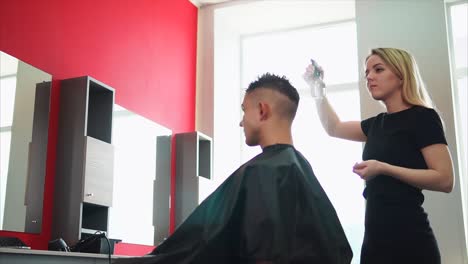 hair stylist applying hairspray to client