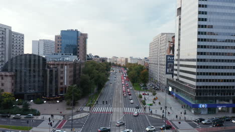 Forwards-fly-above-wide-multilane-boulevard-in-city.-Rush-hour-on-road,-stream-of-slowly-moving-cars.-Warsaw,-Poland