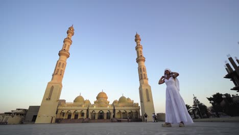 mujer turista visitando la mezquita de el mina con el hijab tradicional y un largo vestido blanco en hurghada, egipto