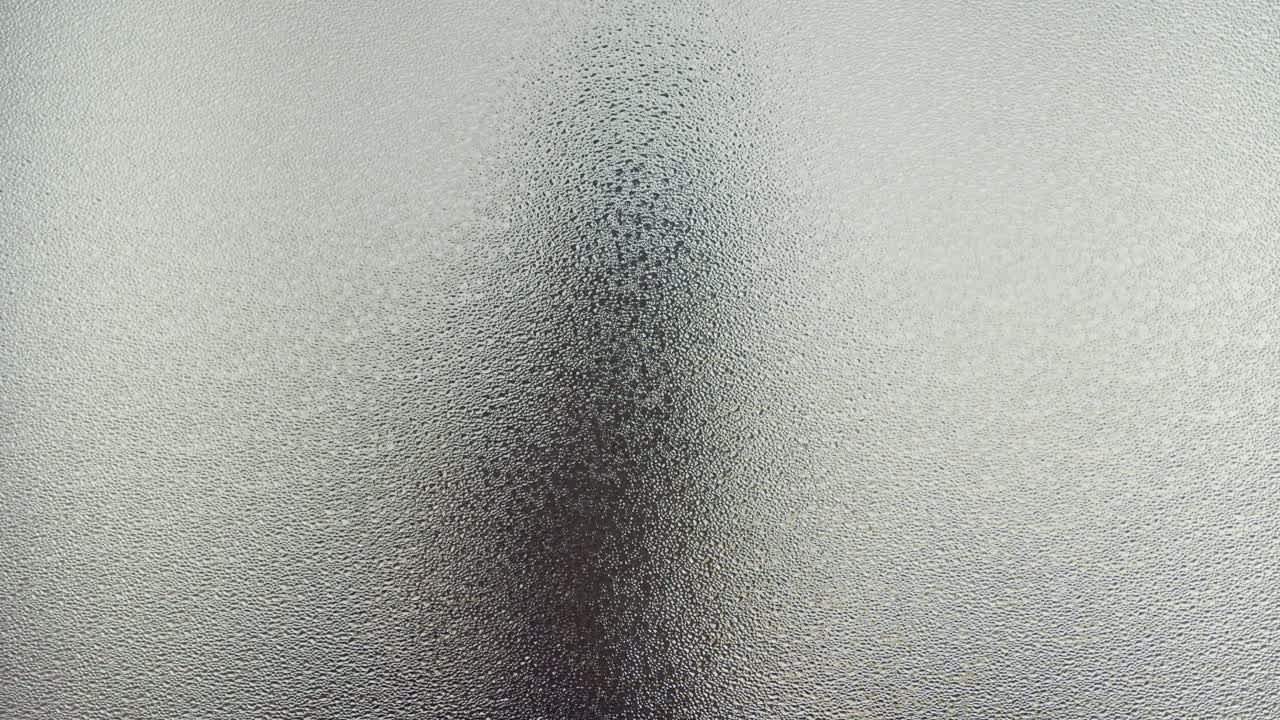 A female silhouette behind the frosted window touches the glass slowly