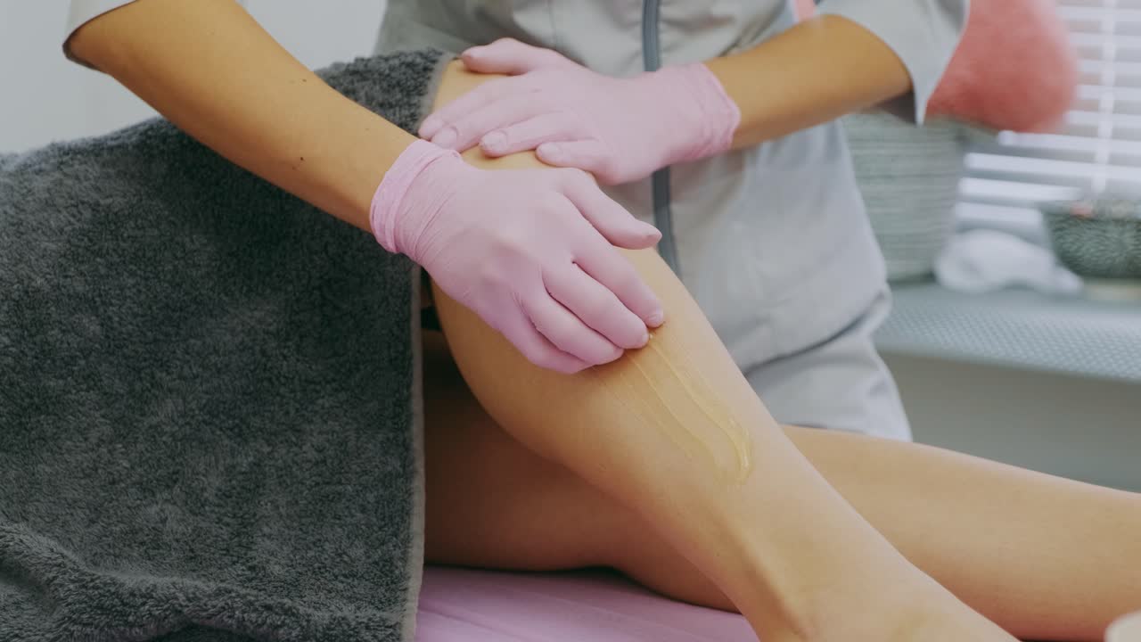 Depilazione delle gambe femminili con pasta di miele o zucchero. Rimozione dei peli con sugaring. Concetto di bellezza. Sugaring. Processo di epilazione. Gambe