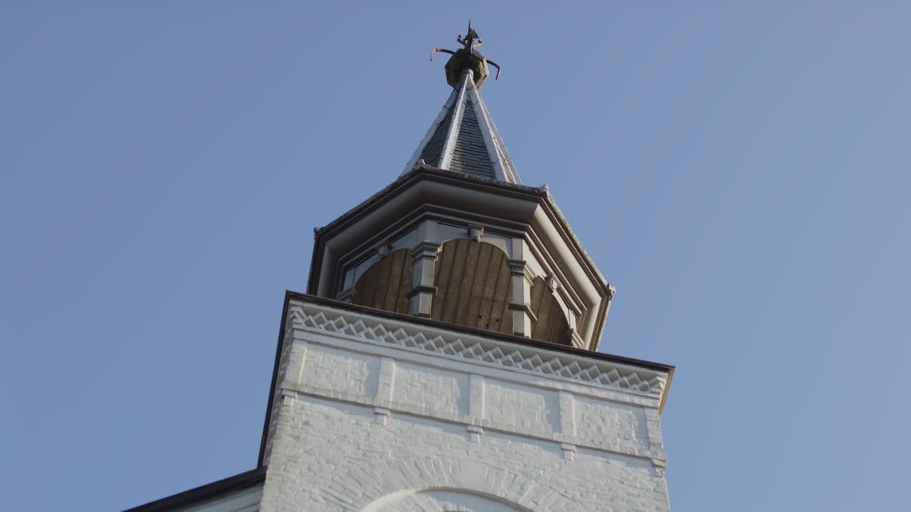 Beautiful close pan of a old white church tower on a sunny day