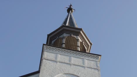 beautiful close pan of a old white church tower on a sunny day