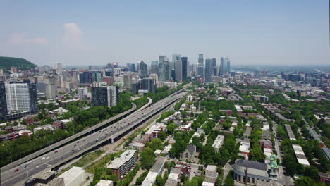 Toma-Aérea-De-Seguimiento-Del-Bulevar-Ville-Marie-Y-Petite-bourgogne,-En-La-Soleada-Montreal,-Canadá.