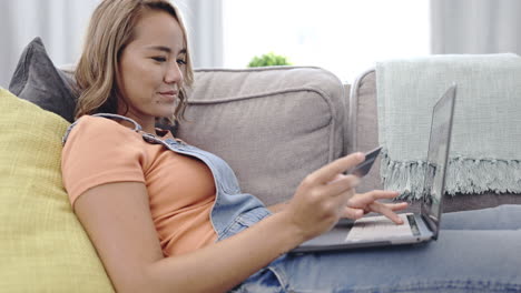 mujer asiática, tarjeta de crédito y portátil en línea