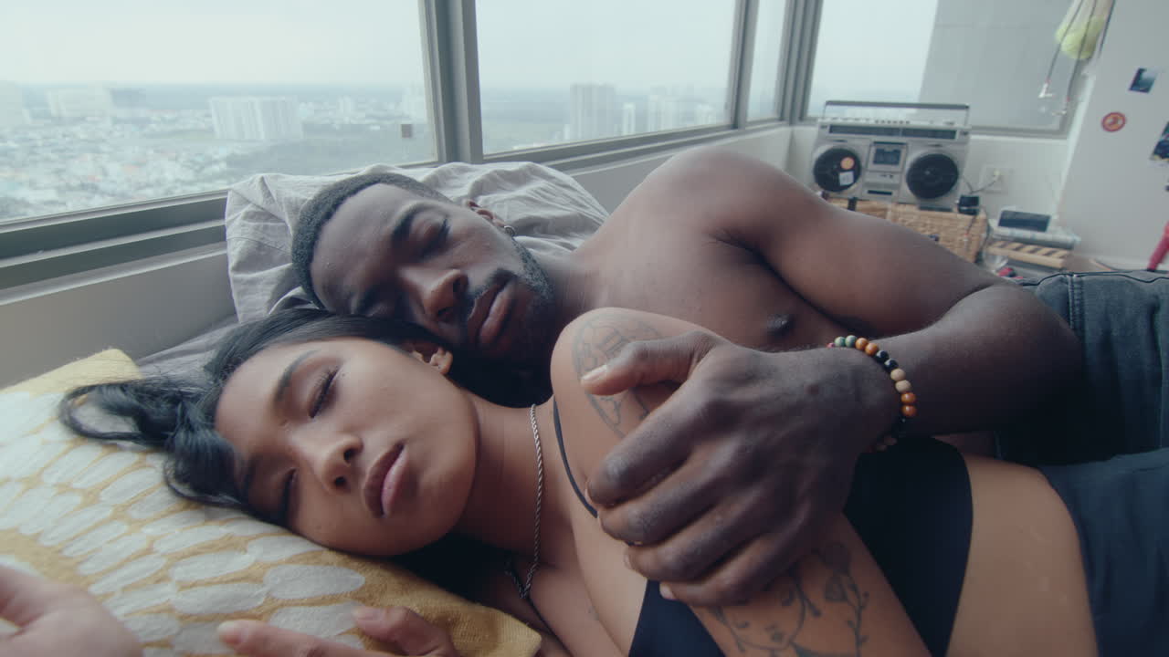 Young Multi-Ethnic Couple Sleeping and Cuddling in Bed