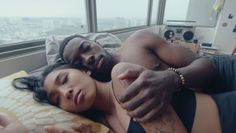 young multi-ethnic couple sleeping and cuddling in bed