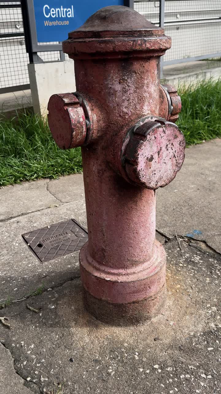 4K close-up of a weathered, rusty fire hydrant. The aged texture and faded color create a gritty, industrial aesthetic perfect for urban or vintage-themed visuals.
