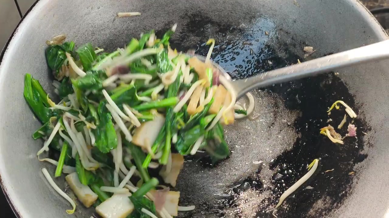 Le verdure di senape, i germogli di soia e le polpette di pesce sono fritti velocemente in un wok caldo. Vengono aggiunti ingredienti aromatici come cipolle e acciughe. Questo crea un pasto delizioso e saporito che mantiene le verdure croccanti.