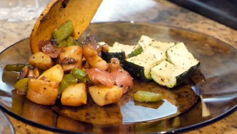 roasted potatoes and mixed vegetables served on glass plate