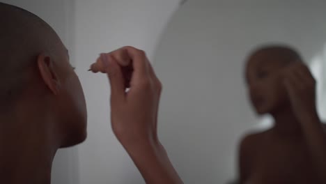 charming woman doing makeup at home