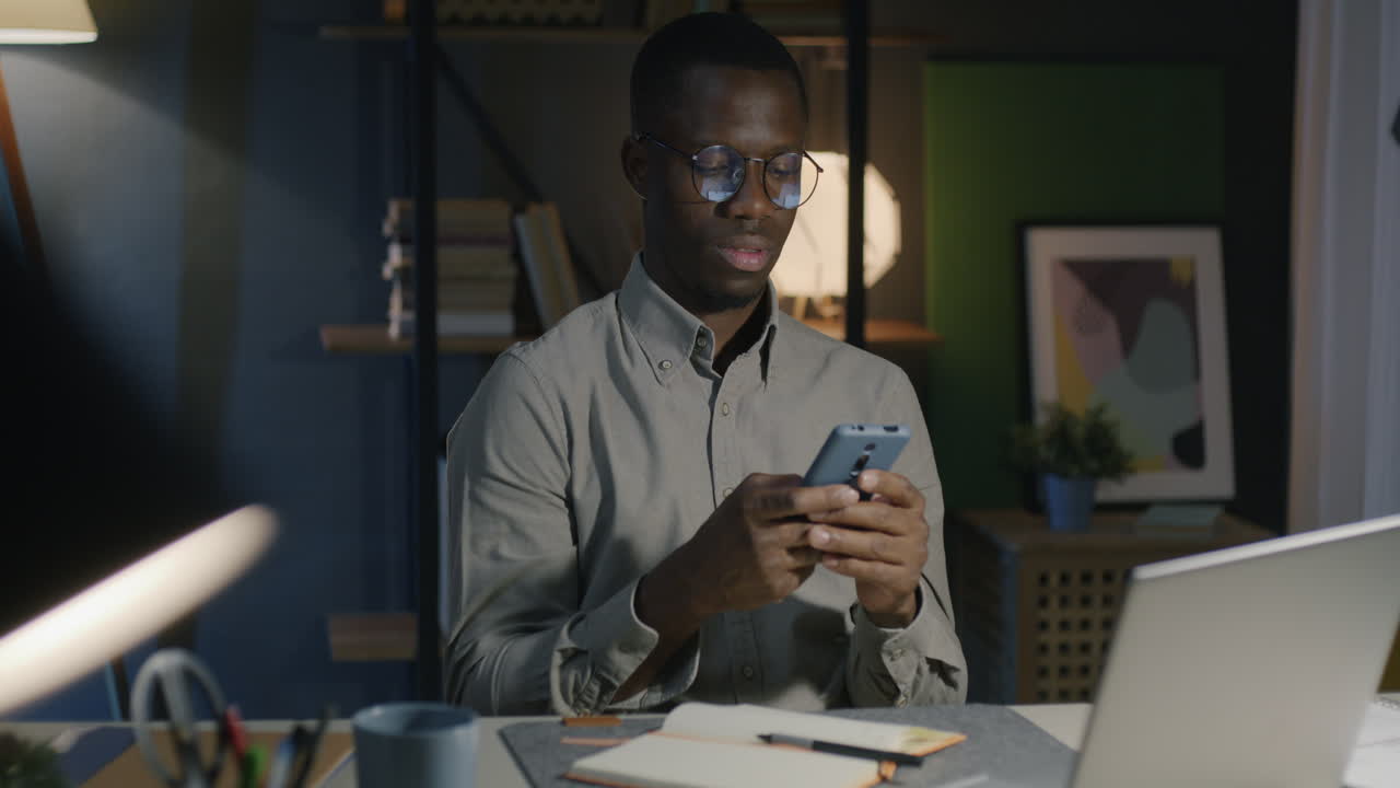 Man Working Late at Night on Smartphone in Home Office