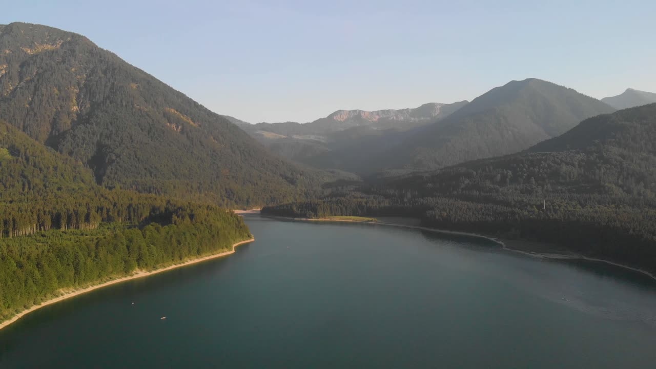 오스트리아 알프스의 전문적인 항공 샷, 황금 시간 동안 산과 거대한 화강암 벽을 향해 날아갑니다.
