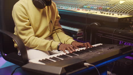 Black-Man-Playing-Synthesizer-in-Recording-Studio