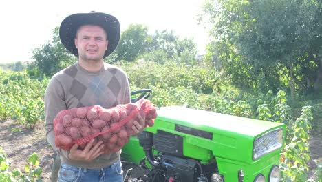charismatic senior farmer holding a bag of potatoes a farmer in a field stands with a bag of potatoes agriculture