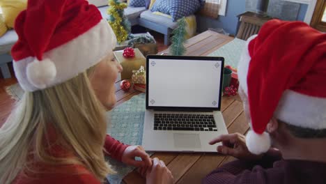 Glückliches-Kaukasisches-Reifes-Paar-Mit-Weihnachtsmützen-Und-Laptop-Mit-Kopierplatz