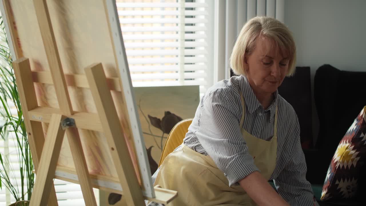 고위 여성 예술가가의 비디오가 그림을 그리는 것을 끝 ⁇ 니다.