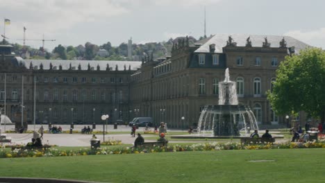 behind pavilion view of stuttgart parliament building and tourists walking downtown square at noon, germany, europe, panning view angle