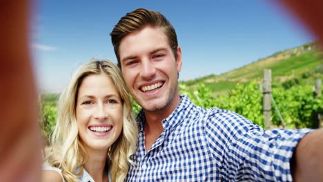 Portrait-of-happy-couple-enjoying-in-vineyard