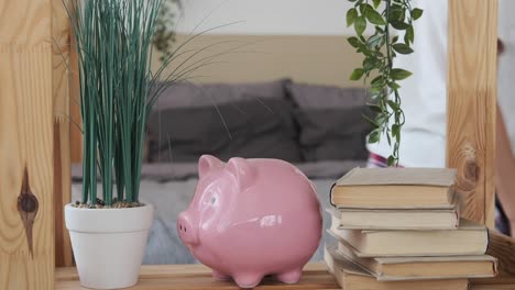 boy inserting coin into piggy bank