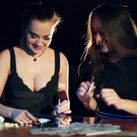 very funny women sniff cocaine on the mirror with a roll of banknotes. drug abuse (imitation)