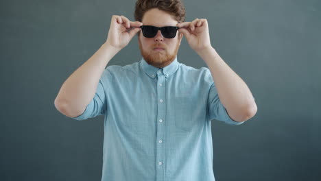 man adjusting sunglasses