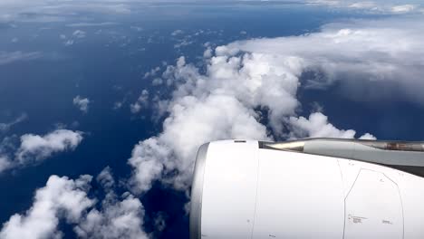 Blick-Aus-Dem-Fenster-Eines-Verkehrsflugzeugs-Auf-Einem-Flug-über-Einen-Blauen-Ozean-Mit-Einem-Strahltriebwerk-Im-Rahmen