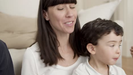 Adorable-little-boy-sitting-on-mom-lap-and-eating-fresh-apple