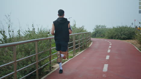 professional runner training outdoors in sportswear. sporty man jogging track