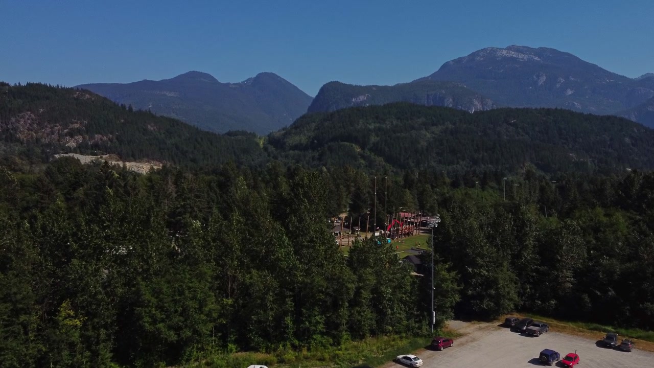 Una vista panoramica mozzafiato delle montagne Squamish nella Columbia Britannica, Canada. Cieli azzurri e foreste lussureggianti rivelano un maestoso paesaggio selvaggio