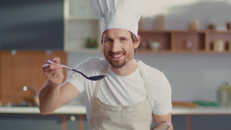 hombre degustando sopa en la cocina