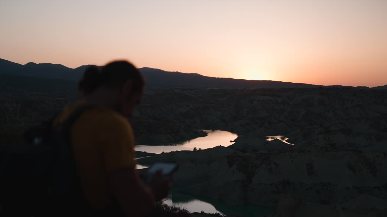Il tramonto su un lago con le montagne sullo sfondo