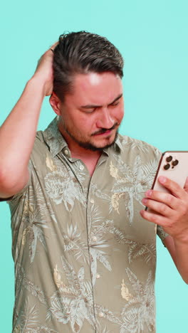 man frowning looking at smartphone screen receiving bad news or losing online game with frustration