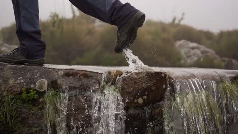 stepping over a waterfall in itatiaia, minas gerais, brazil, in nature