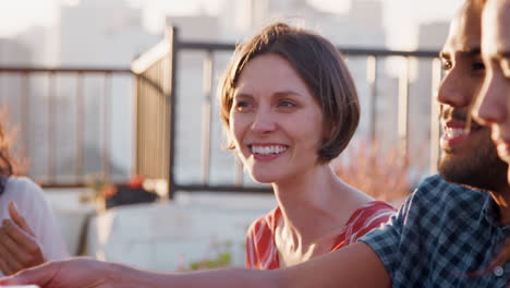 friends gathered on rooftop terrace for meal with city skyline in background