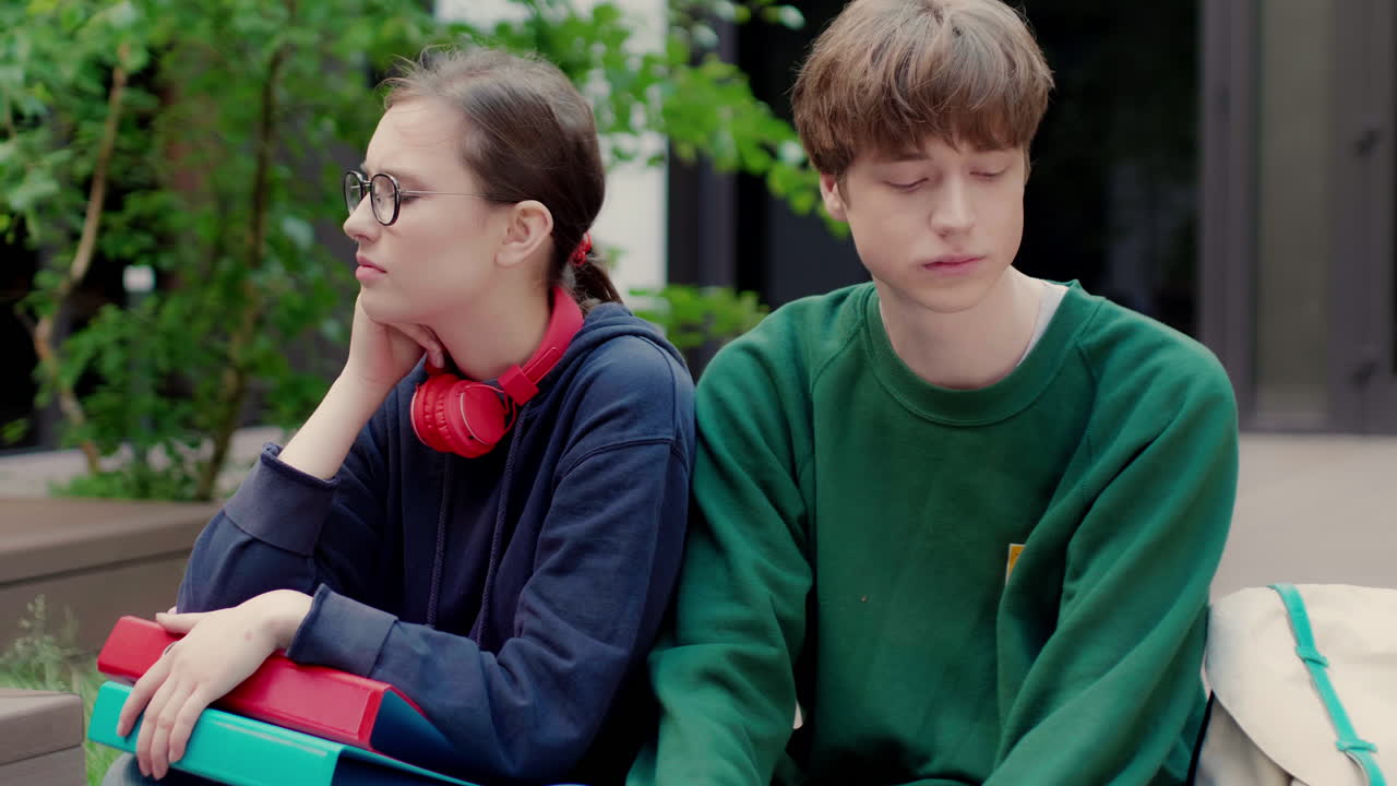 두 명의 백인 친구가 대학 캠퍼스에서 화를 내고 있습니다.