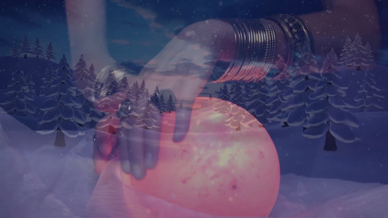 Hand with bracelets touching glowing orb over snowy forest animation