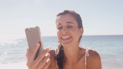 mujer soplando un beso frente a su teléfono inteligente