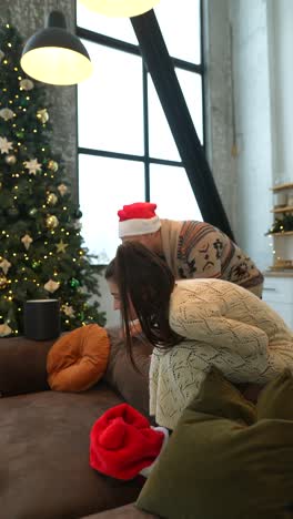 una pareja celebra la navidad en casa con un perro.