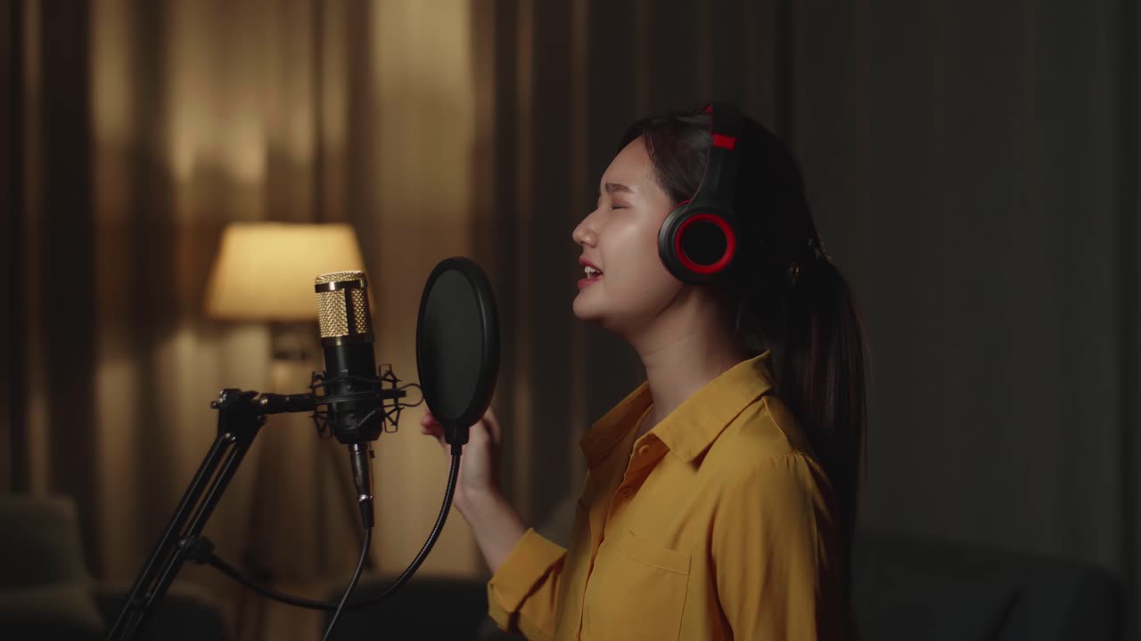 가정 스튜디오 에서 마이크 로 노래 하는 여자