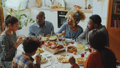 african american family members talking over holiday dinner at home
