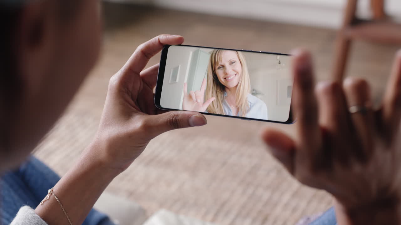 mujer sorda mujer que usa un teléfono inteligente video chateando con su mejor amiga comunicándose con lenguaje de señas gestos con las manos disfrutando de la comunicación en línea
