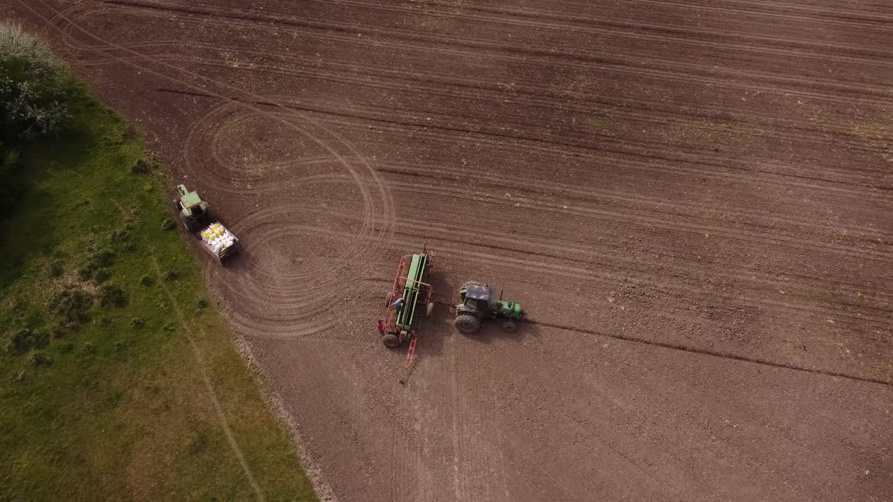vista aérea de granjeros que arreglan maquinaria industrial y tractores en una granja agrícola