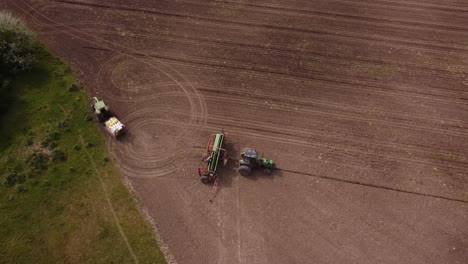 aerial top down of farmers fixing industrial machinery and tractor an agriculture farm