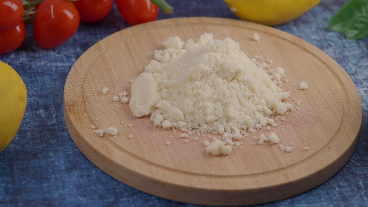 Grated Parmesan Cheese on Wooden Board with Fresh Ingredients