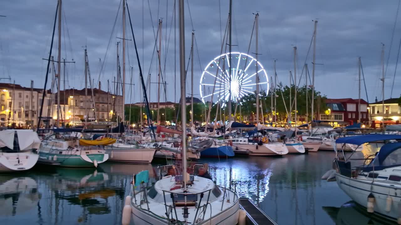 Panoramic view of sunset night with boats at Quai Valin and illuminated Ferris wheel, La Rochelle, Charente-Maritime, France
