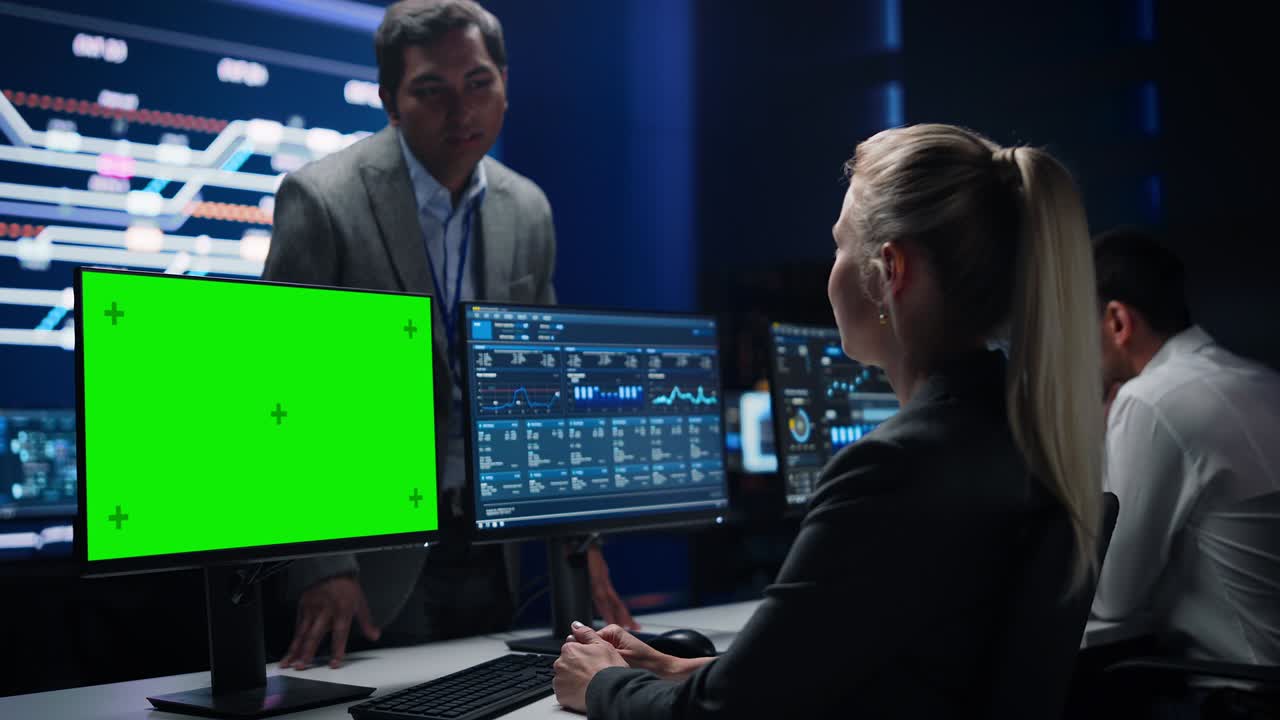 Female Specialist Works on Green Screen Computer Talks with Project Manager in Big Infrastructure Control Room. Monitoring Room Team of Professionals Use Computers Showing Charts, Information